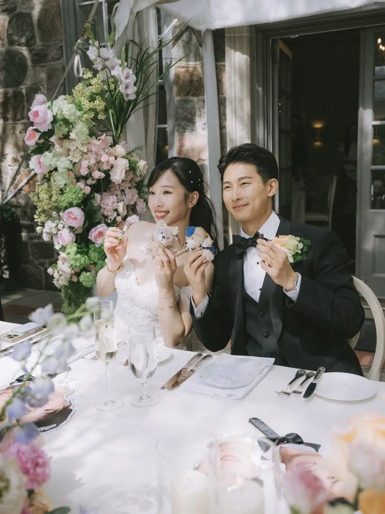 Newlyweds seated at a floral reception table