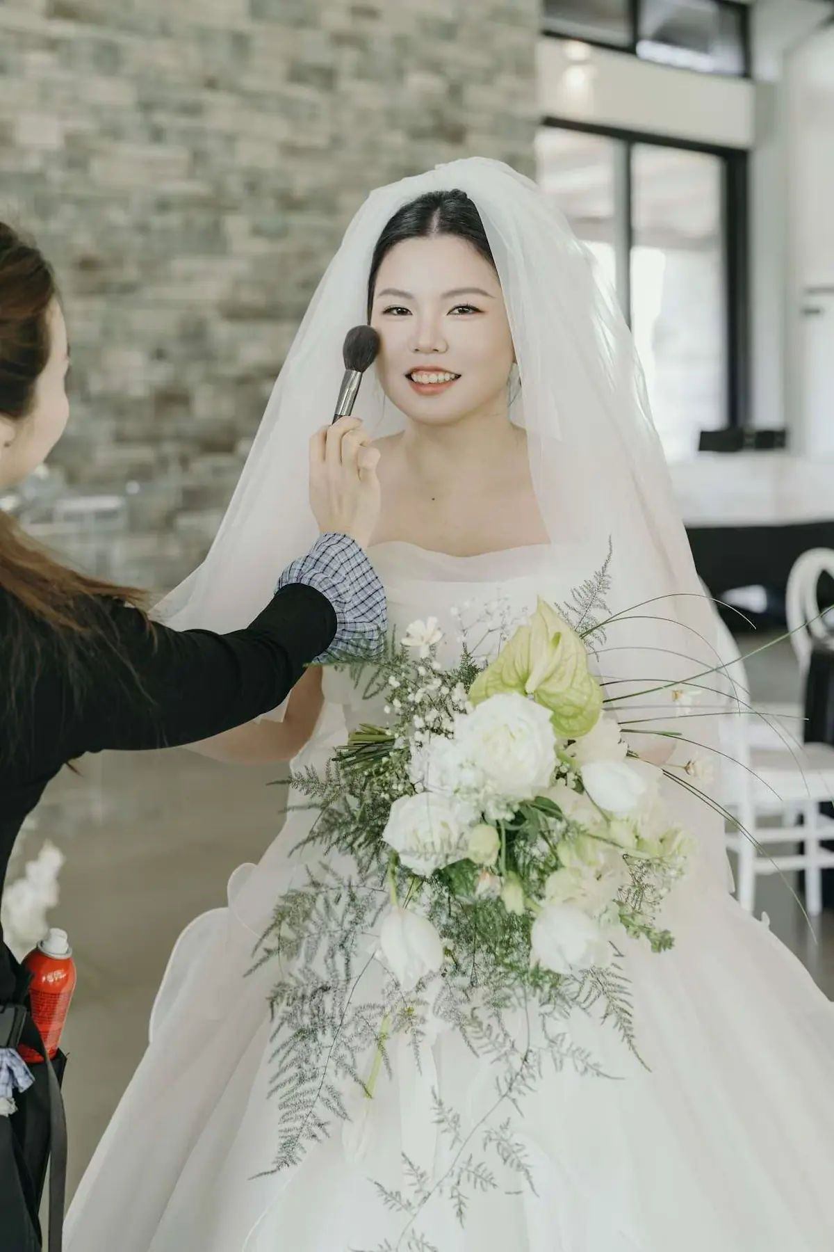Bride holding a white bouquet during wedding preparations