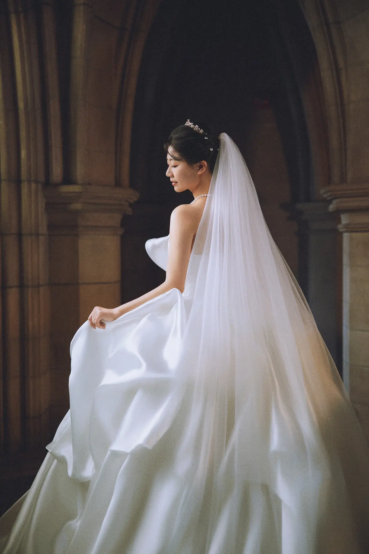 Bride in a sculptural gown and veil by Elaine