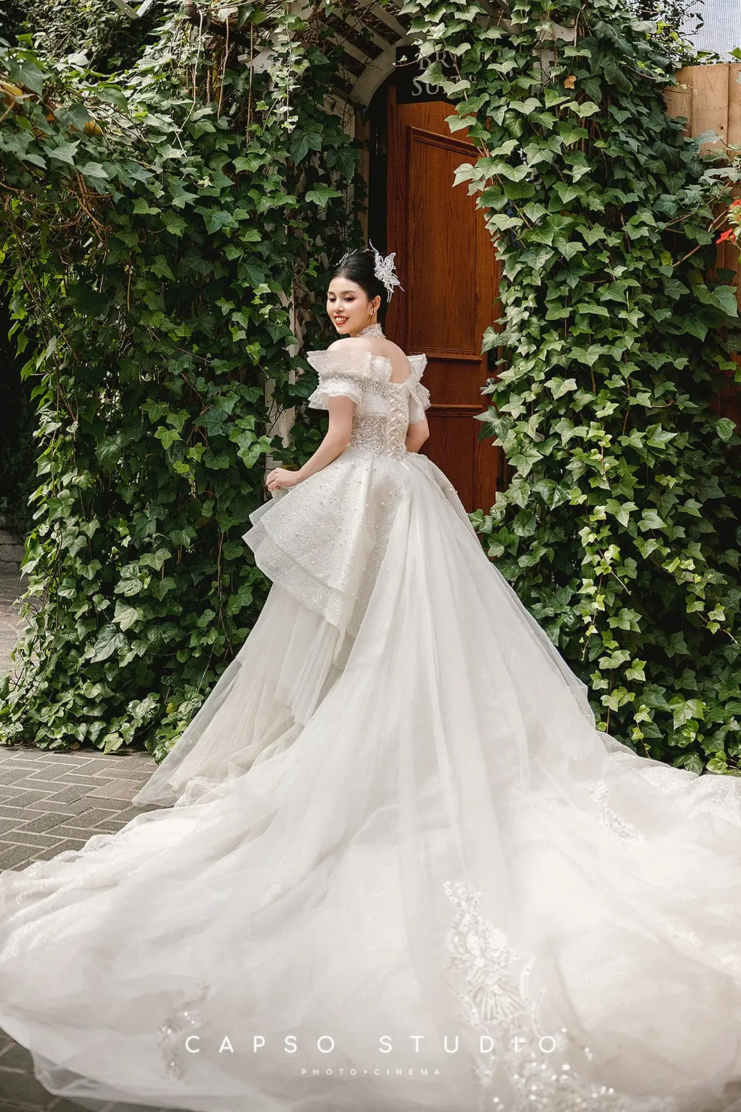 Full-length bride in an ivy-lined courtyard