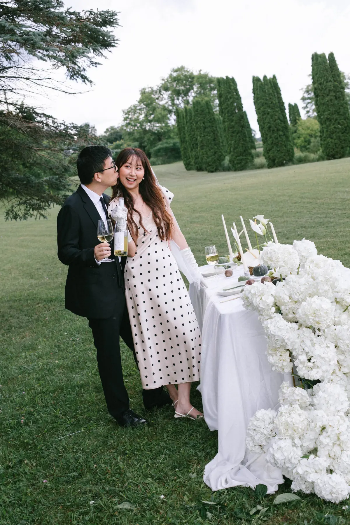 Bride and groom beside an outdoor reception table
