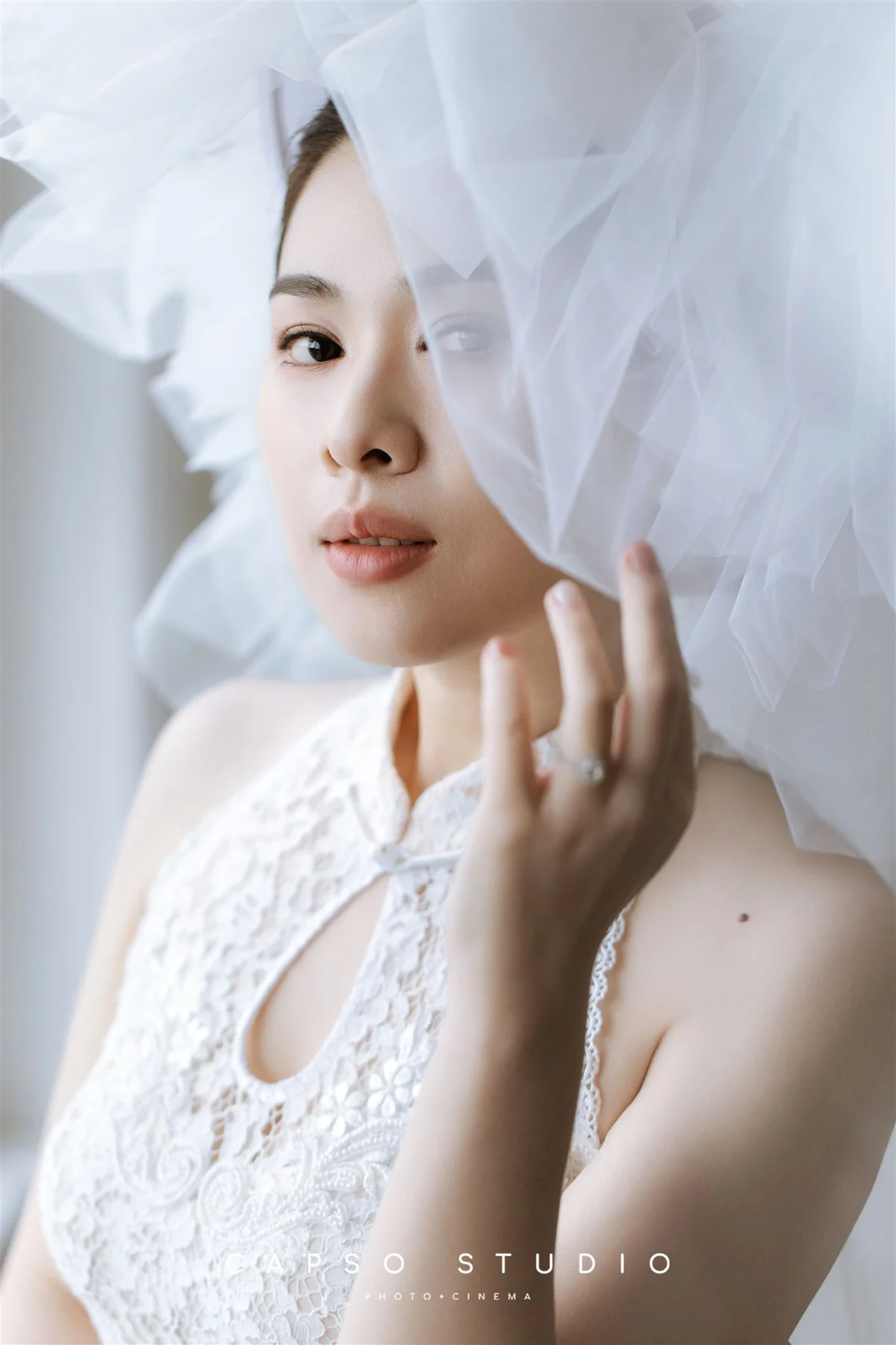 Soft bridal beauty beneath a sheer veil by Mira