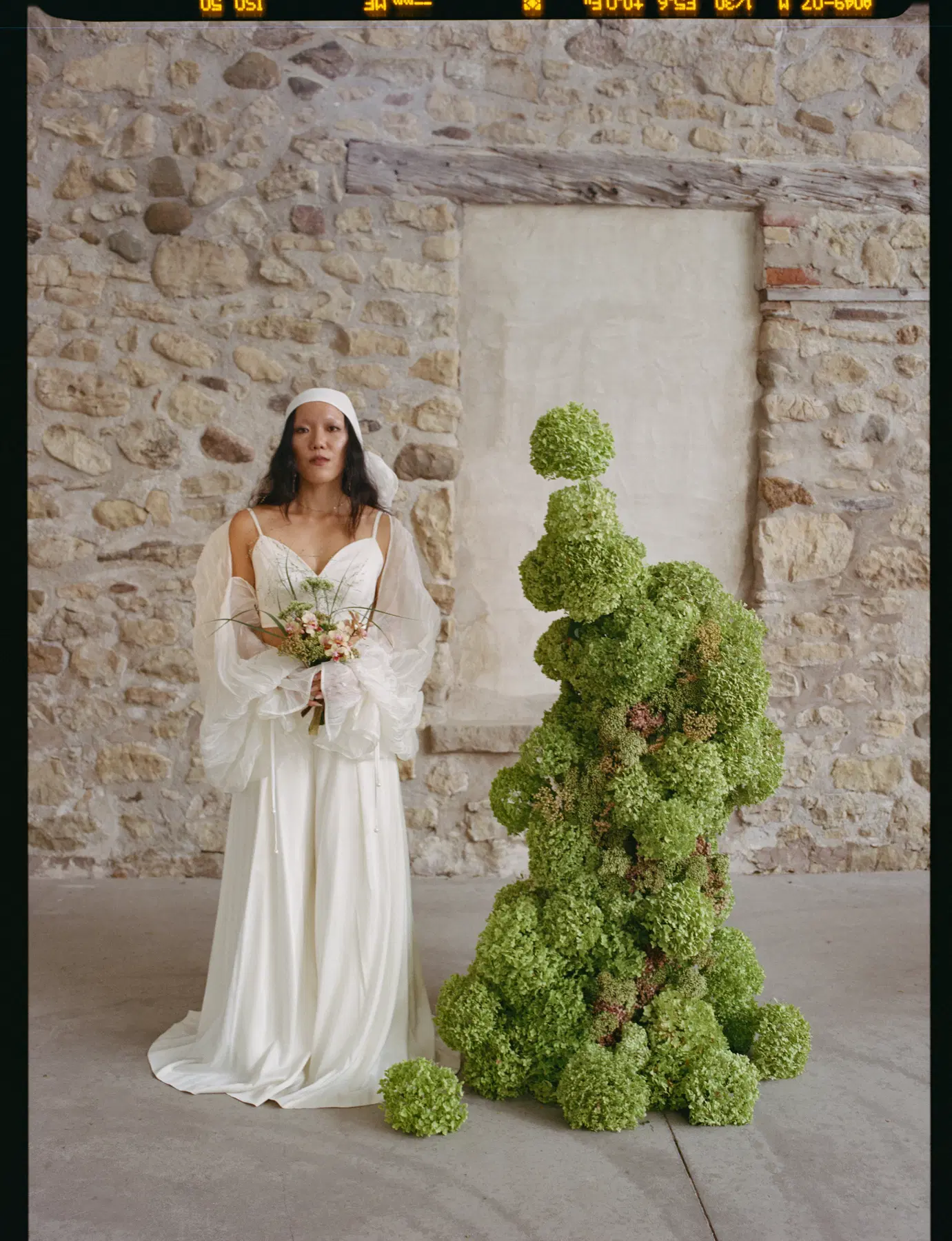Bride beside sculptural green florals