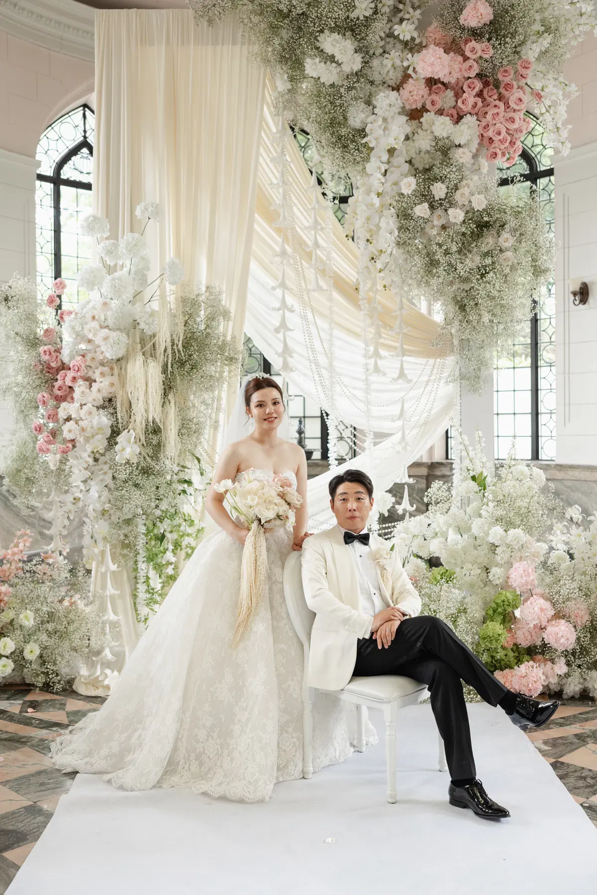 Wedding couple beneath a floral installation