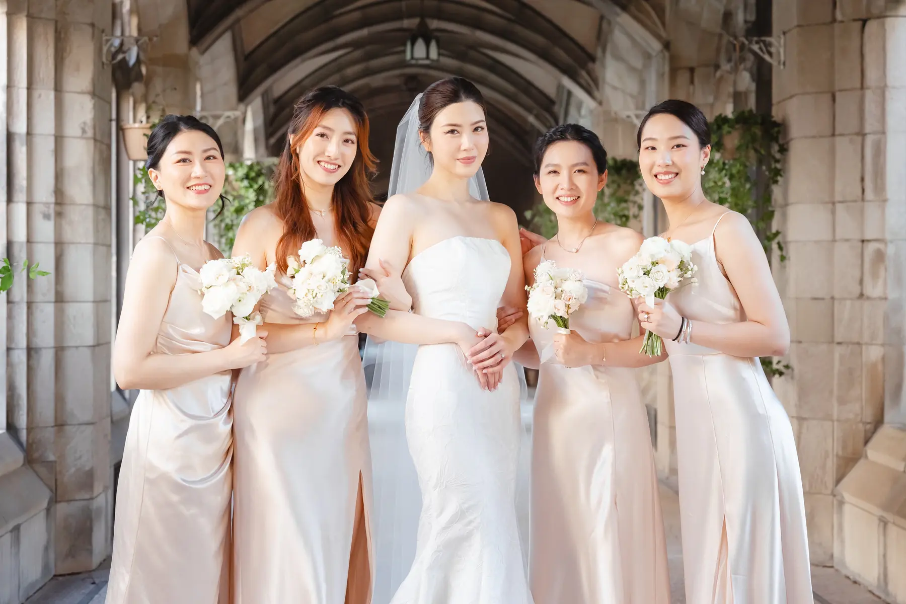 Bridal party portrait in a stone corridor