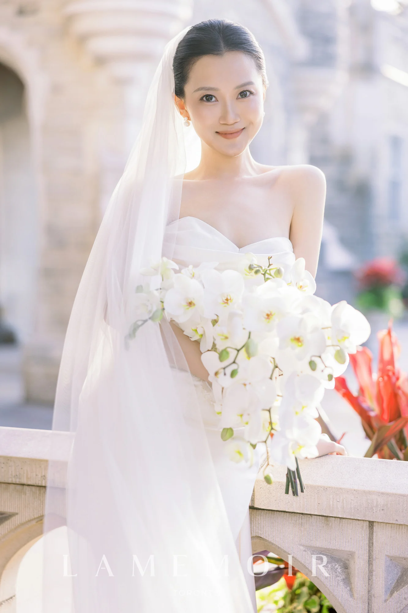 Bride holding a cascading white orchid bouquet
