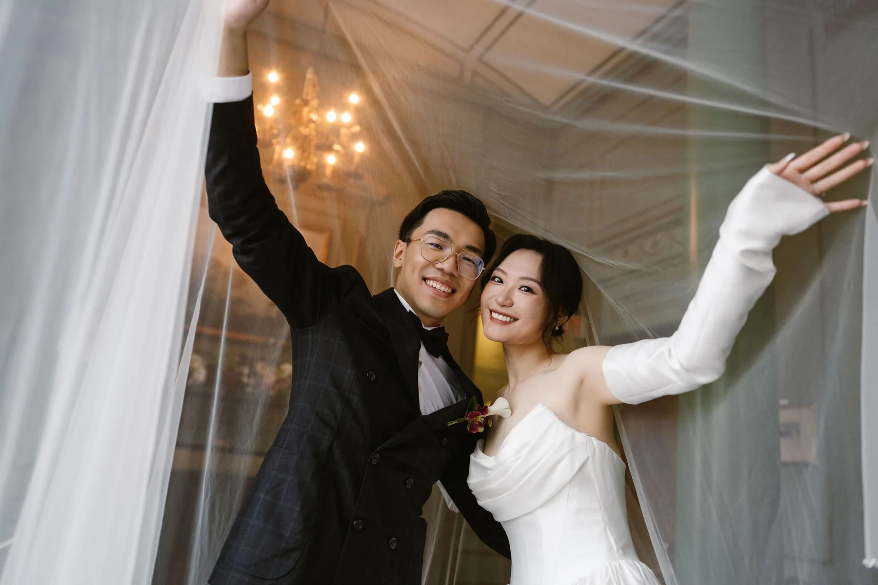 Wedding couple celebrating beneath a veil
